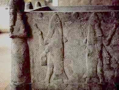 Alte Reliefdarstellung auf Stein mit eingravierten Figuren, die möglicherweise astronomische Symbole darstellen, einschließlich einer menschenähnlichen Figur und symmetrischen Mustern.