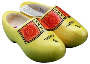 Ein Paar traditionelle, handbemalte Holzschuhe in Gelb mit rot-orangen Verzierungen und symbolischen Mustern.