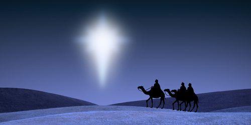 Drei Reiter auf Kamelen wandern durch eine schneebedeckte H&uuml;gellandschaft bei Nacht, w&auml;hrend ein leuchtendes Himmelsph&auml;nomen, &auml;hnlich einem Stern, intensives Licht vom Himmel strahlt.