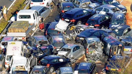 Gro&szlig;aufnahme eines schweren Verkehrsunfalls auf einer Autobahn, bei dem viele Autos und Transportfahrzeuge ineinander verkeilt und besch&auml;digt sind.