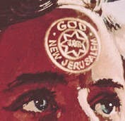 Nahaufnahme von einem Teil eines Gesichts mit sichtbaren Augen und einer Stirn, auf der ein roter Stempel mit der Inschrift "GOD NEW JERUSALEM" und einem Stern in einem Kreis abgebildet ist.