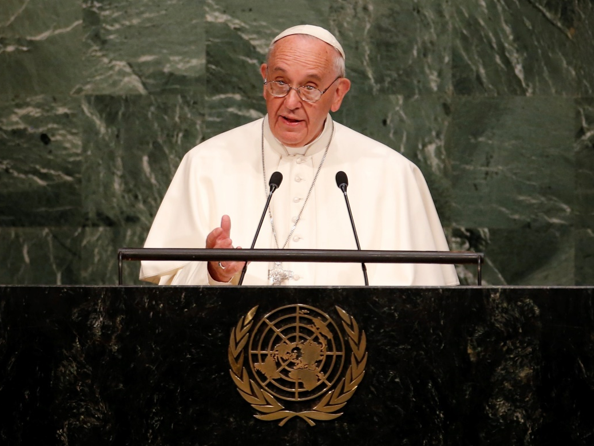 Ein Mann in religi&ouml;ser Kleidung steht an einem Rednerpult, auf dem das Emblem der Vereinten Nationen zu sehen ist, und h&auml;lt eine Rede.