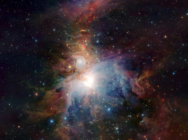 Eine leuchtende Sternentstehungsregion im Weltraum, umgeben von wolkenartigen Gasen in verschiedenen Farben und kleinen Sternen um den zentralen hellen Stern.