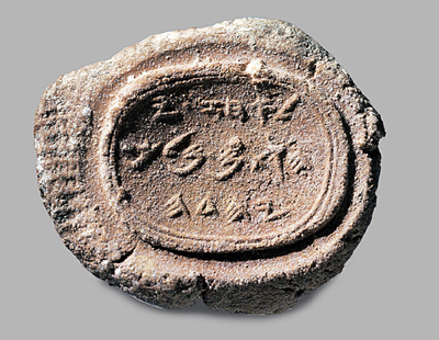 Antikes Siegel mit eingravierten Schriftzeichen und Symbolen aus dem Mazzaroth umgeben von einem ovalen Rahmen auf einem hellgrauen Hintergrund.