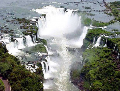 Luftaufnahme eines gro&szlig;en Wasserfalls mit mehreren Wasserstr&ouml;men, die in ein bewaldetes Tal hinabst&uuml;rzen.